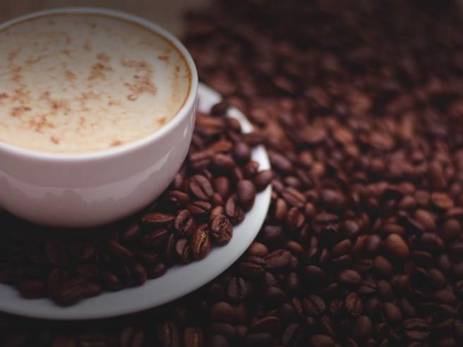 Cappuccino beside coffee beans